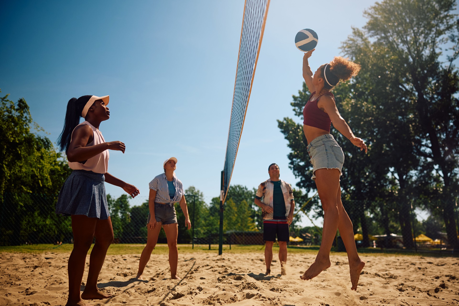 Group of friends playing volleyball on the beach.